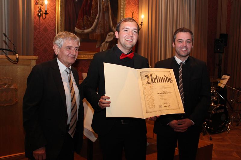 Daniel Reisner (Mitte) erhielt seine Urkunde von Bürgermeister Thomas Herker (rechts) und Musikreferent Peter Feßl.