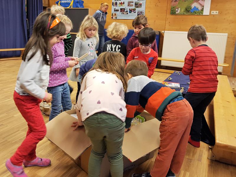 Die Kinder packen ungeduldig das Entdeckerpaket aus.