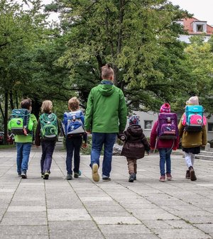 Kinder auf dem Schulweg mit Begleitung