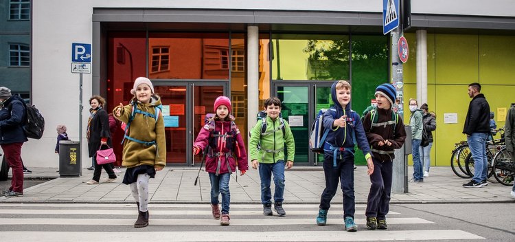 Schulkinder gehen über einen Zebrastreifen