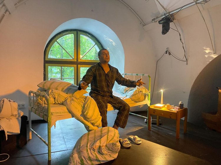 Mann sitzt aufrecht in seinem Bett mit erschrockenem Gesichtsausdruck.