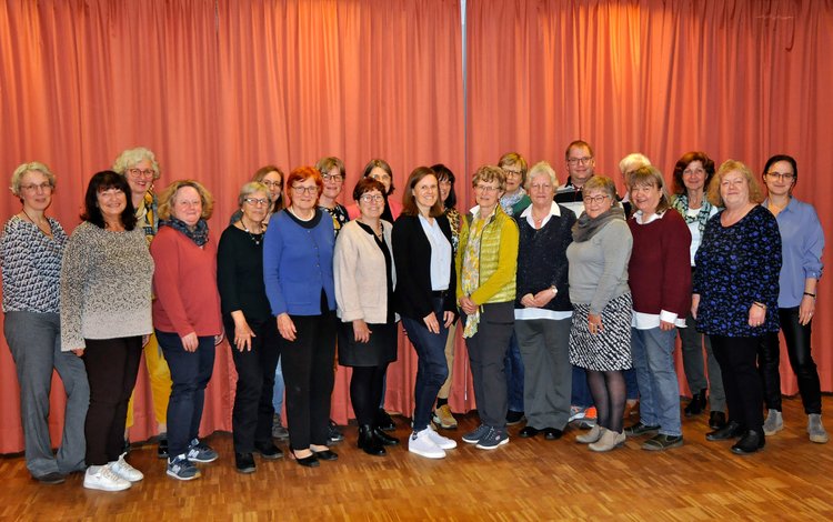 Gruppenfoto der Ehrenamtlichen Helferinnen und Helfer der Stadtbücherei vor einem roten Vorhang.