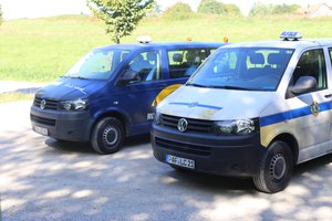 Zwei Busse der Rufbuslinie stehen auf einem Parkplatz