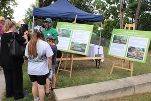 Besucher stehen vor Schautafeln zum Thema Klimaschutz und Wald