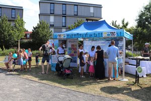 Gesamtansicht des Standes mit Menschen, die sich zum Klimaschutz informieren