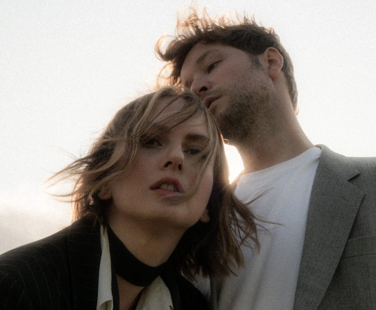 Mann blickt Frau an und Frau blickt in die Kamera