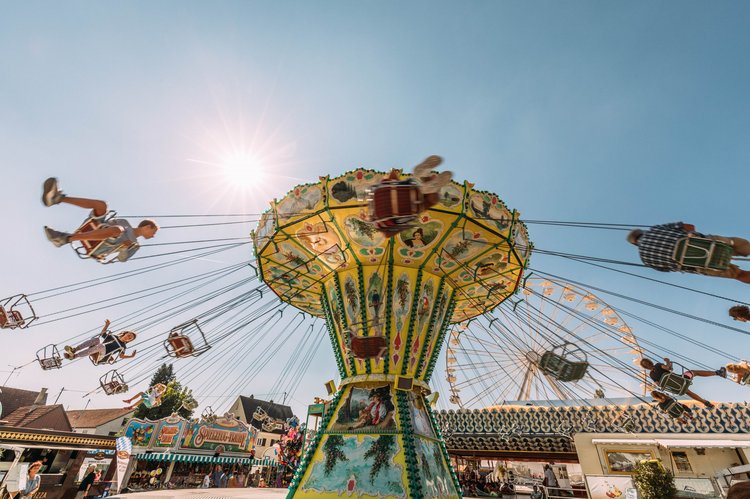 Kinder auf dem Kettenkarussel, im Hintergrund das Riesenrad.