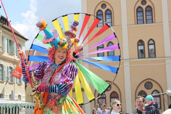 Verkleidete Frau auf Stelzen